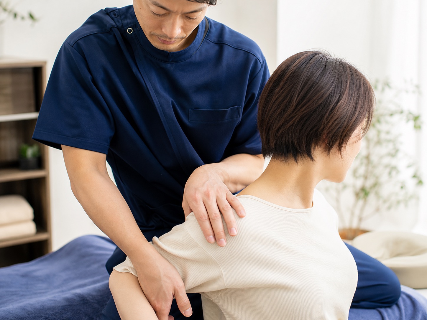 肩まわりの状態を確認しながら施術する院長の様子。